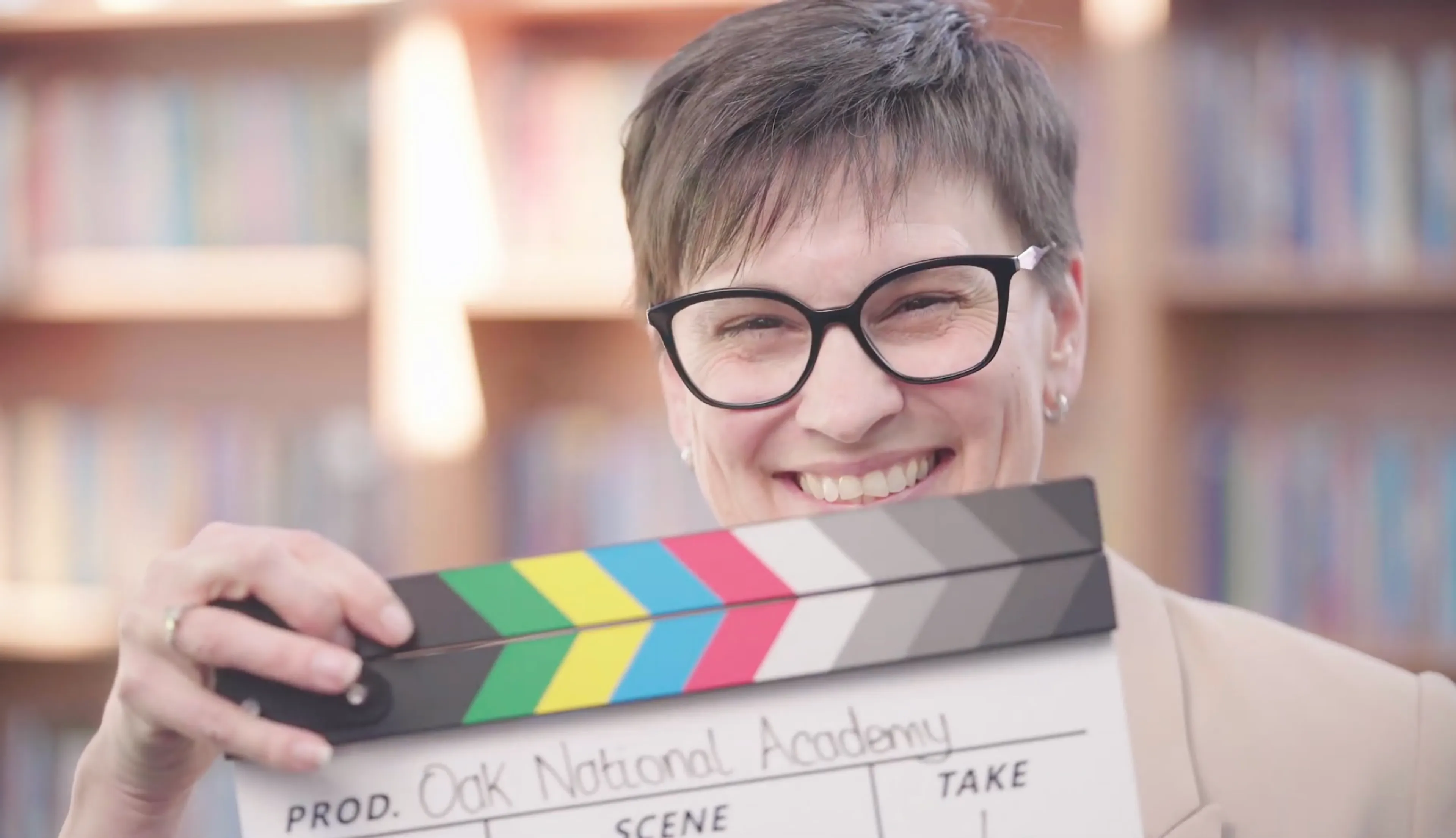 A deputy headteacher holding a filming clapperboard