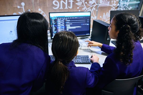 Pupils gathered around a computer in school