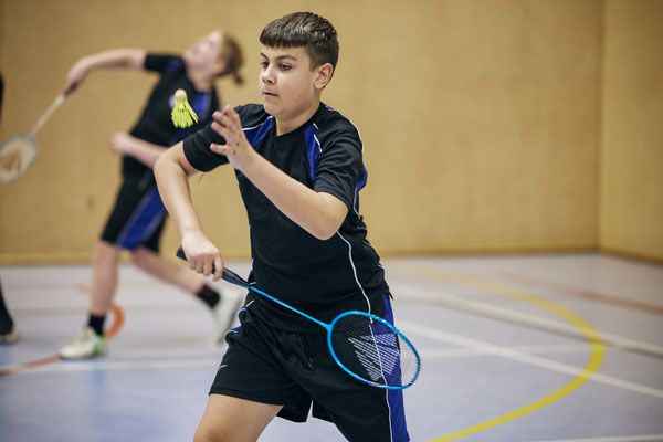 A pupil playing badminton in a PE lesson
