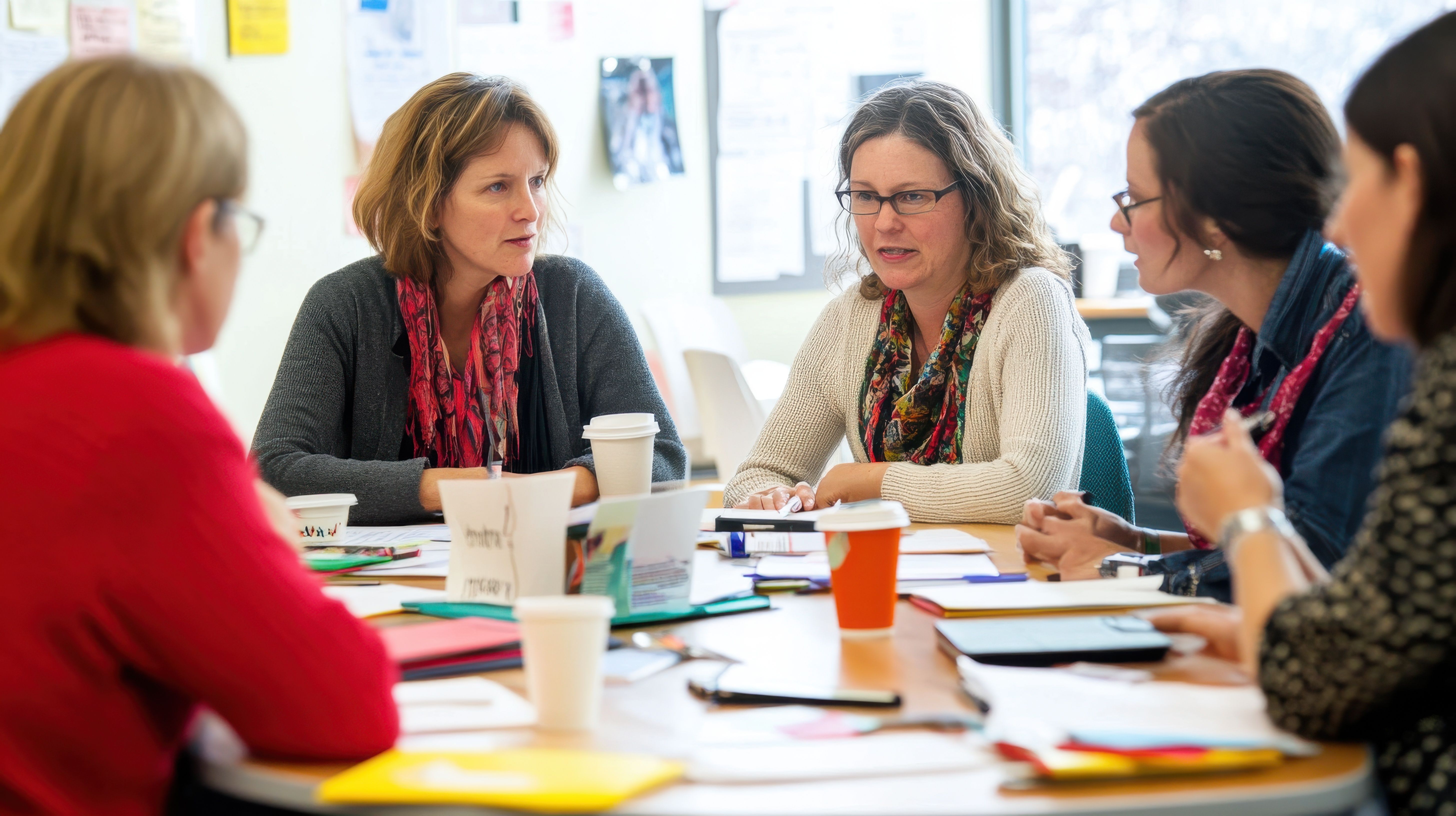 A group of teachers sat working together in a meeting around a table.