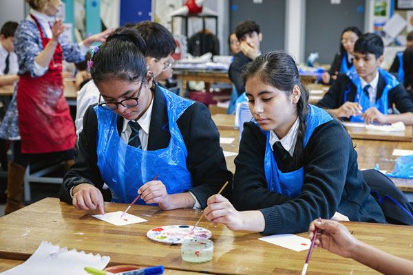 Secondary pupils painting in an art lesson